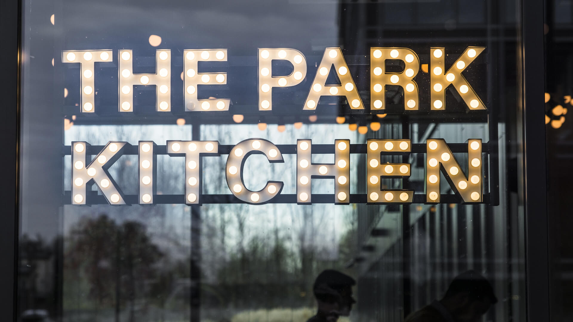 The Park Kitchen - małe litery z żarówkami umieszczone za szybą